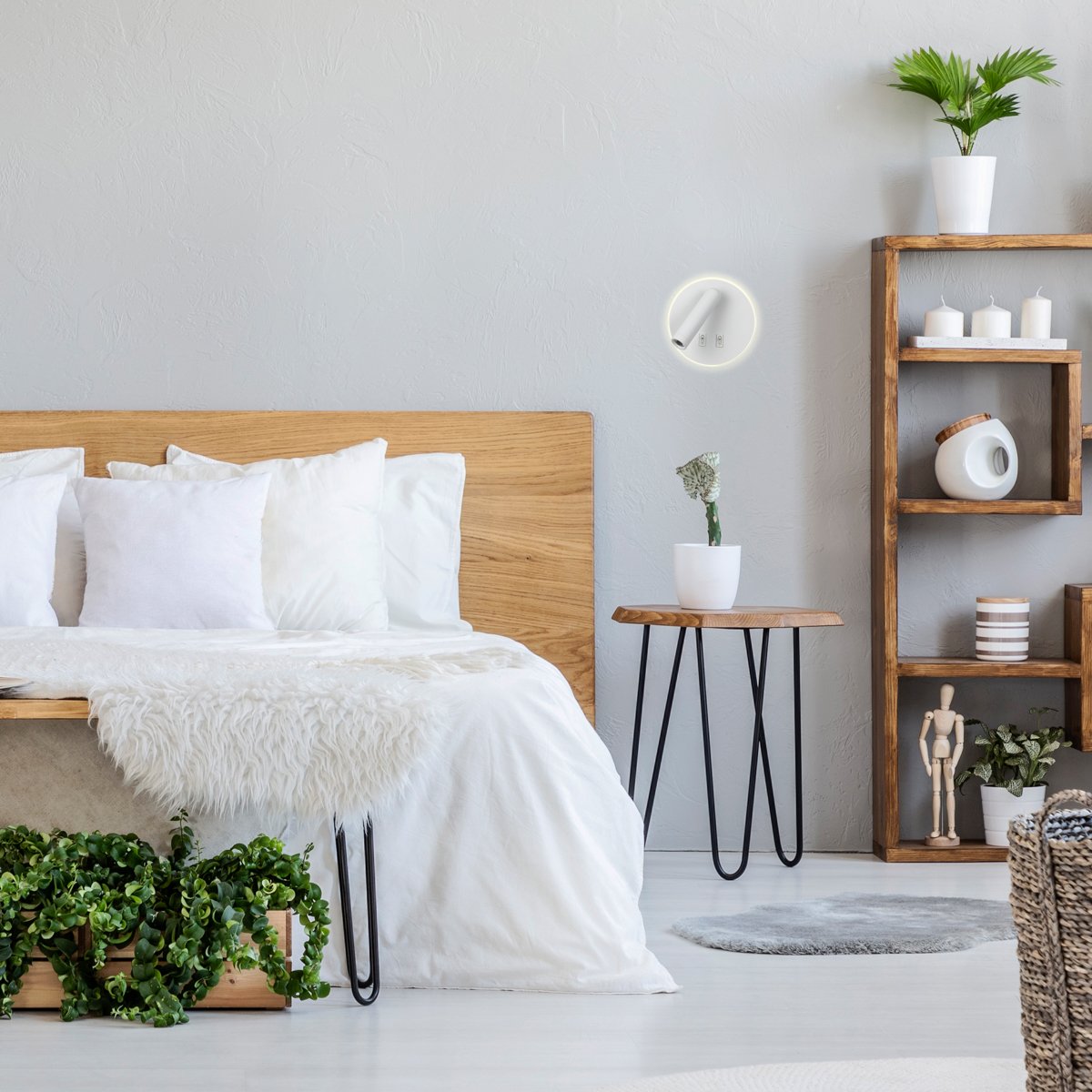 Patterned pouf and basket in bright bedroom interior with lamps, plants and poster next to bed. Real photo